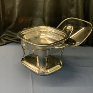 Gold metal chafing dish with lid on stand, reflective surface and elegant design for catering events.