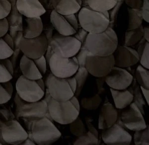 Dark gray overlapping stone-like scale or petal texture with shadowed, layered surface.