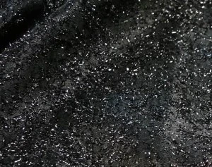 Black sequin tablecloth with sparkly metallic texture and shimmering scattered sequins.