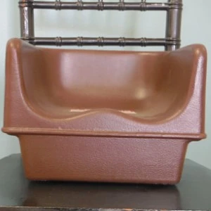 Terracotta-brown molded plastic event rental chair with curved seat and textured finish.