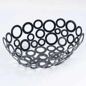 Black metal decorative bowl with interlocking circle cutouts, modern openwork design.