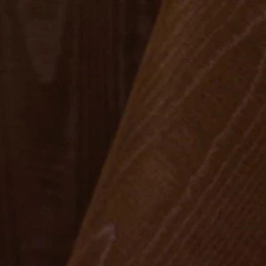 Dark brown wooden surface with textured wood grain showing vertical lines and shadow.