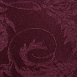 Deep burgundy textured fabric with elegant swirling leaf damask pattern for event linens.