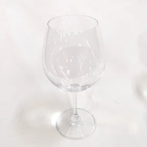 Empty clear wine glass with long stem on white background for event tableware rentals.