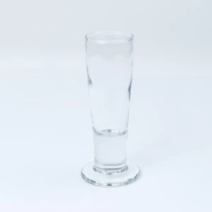 Tall, clear glass shot glass on white background for event beverage service.