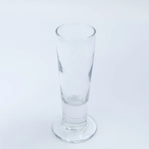 Clear tall shot glass with sturdy base, transparent thin-walled drinking vessel for event rentals.