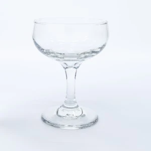 Clear glass champagne coupe with elegant stem and round base for event rentals.