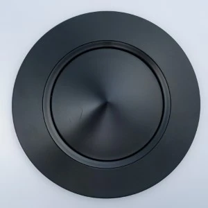 Matte black round plate or charger with concentric circular texture and smooth raised edge.