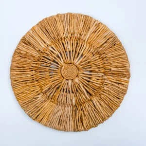 Woven natural rattan circular wall hanging with radial spoke design in warm golden brown tones.