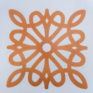 Orange laser-cut decorative tile with symmetrical floral geometric pattern on white background.