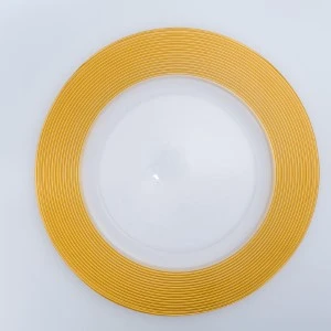 Gold circular event charger plate with radial ridged texture on light background.