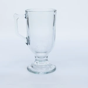 Clear glass Irish coffee mug with pedestal base on white background.