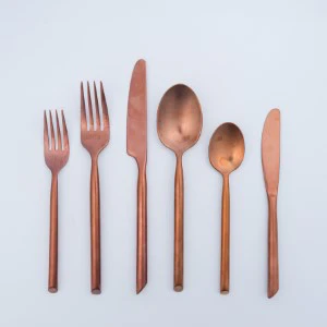 Rose gold utensil set with six flatware pieces arranged neatly on white background.