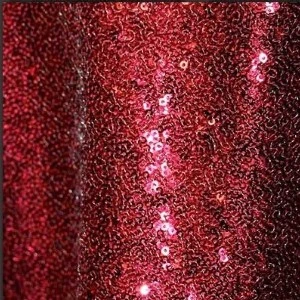 Deep red sequin fabric with shimmering vertical stripe, creating a rich textural event backdrop.