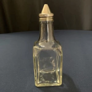 Clear glass square condiment bottle with white screw-top lid for event catering and dining.