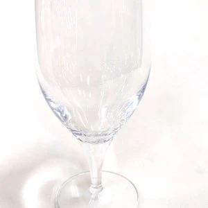 Empty clear glass champagne flute with delicate stem and smooth curved bowl.
