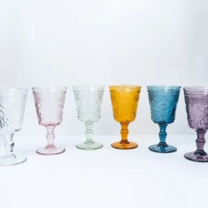 Vintage-style colored wine goblets in white, pink, green, yellow, blue, and purple glass.
