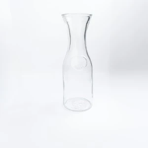 Clear glass wine carafe with slim neck and wide base on minimalist white background.