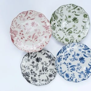 Five ceramic plates with delicate floral patterns in pink, green, blue, and gray colors.