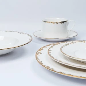 White and gold fine china dinnerware set with delicate ornate gold rim and elegant plating.