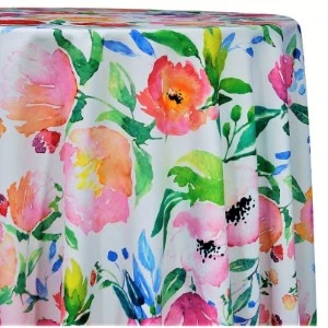 Watercolor floral tablecloth with vibrant pink, yellow, and green flowers on white fabric.