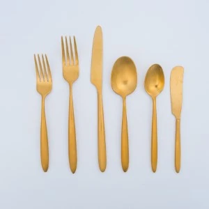 Gold stainless steel flatware set with six utensils in minimalist design on white background.