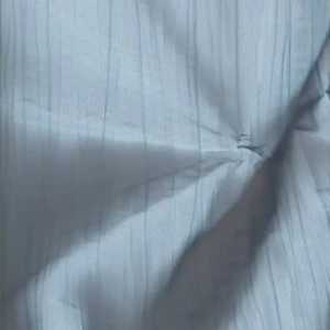 Gray pinstripe fabric with soft wrinkled texture and diagonal light and shadow lines.
