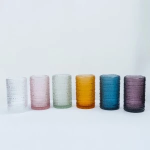 Six textured glass tumblers in pastel and jewel tones lined up in gradient order.