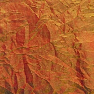 Textured burnt orange and gold crinkled fabric with deep folds and dimensional surface for event linens.