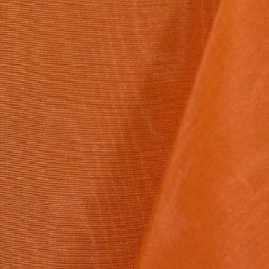 Burnt orange textured fabric with subtle vertical ribbing and soft folds.