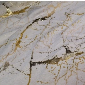Marble-like textured surface with gold metallic veining and cracked white background.