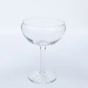 Clear glass coupe champagne stemware with wide, shallow bowl on slender stem.