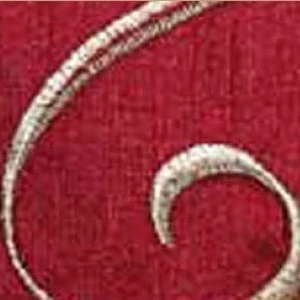 Textured burgundy fabric with curved cream embroidered design detail for event decor.