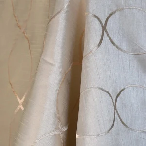 Soft cream and white sheer curtain fabric with delicate circular and linear embroidered pattern.
