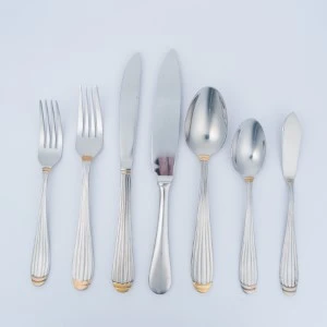 Silver flatware set with six utensils featuring ribbed handles and gold accent tips.