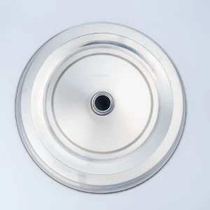 Silver metallic circular serving tray with smooth surface and centered dark hole.