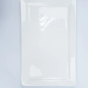 White rectangular ceramic serving platter with embossed border detail on light background.