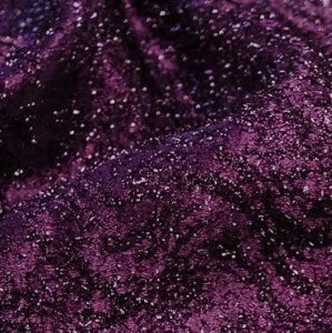Deep purple glittery fabric with sparkling textured surface for luxurious event decor.
