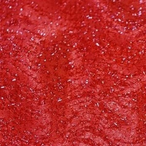 Bright red glitter fabric with shimmering metallic texture for festive event decor.