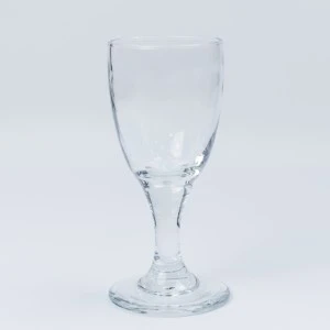 Clear wine glass with narrow stem and round base, elegant event stemware for table rentals.