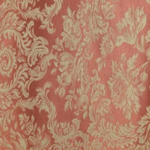Coral and gold damask fabric with ornate floral and scrollwork pattern for event linen rental.