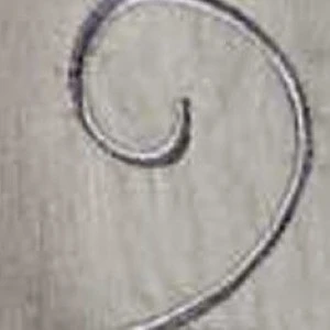 Curved metal wire spiral detail with subtle gray background texture.