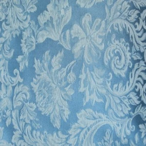 Soft blue damask linen with intricate floral and scrollwork jacquard pattern for elegant event rentals.