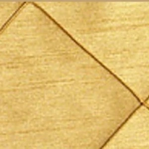 Tan textured linen napkin with crisp folded corner and geometric diagonal line.