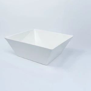White square ceramic serving bowl with angular, geometric sides on neutral background.