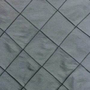 Gray pintuck fabric with diamond-shaped texture and crisp diagonal pleats for event linen rentals.