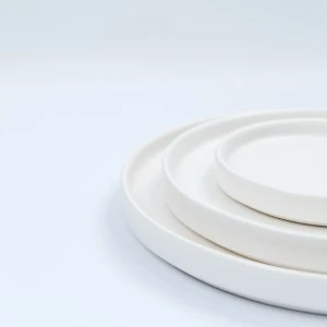Stacked white ceramic plates with smooth, minimalist design and rounded edges.