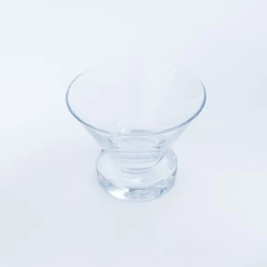 Clear glass small bowl with curved rim and round base on white background.