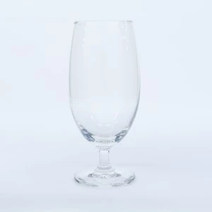 Empty clear glass beer stemmed goblet on white background for event rentals.