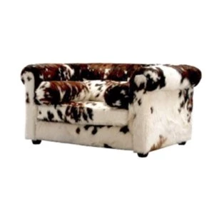 Cowhide leather loveseat with brown and white spotted upholstery and rolled arms.